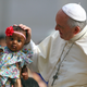 Pope Francis blesses a child as he arrives to lead the Wednesday general audience in Saint Peter’s square at the Vatican, on June 13, 2018.